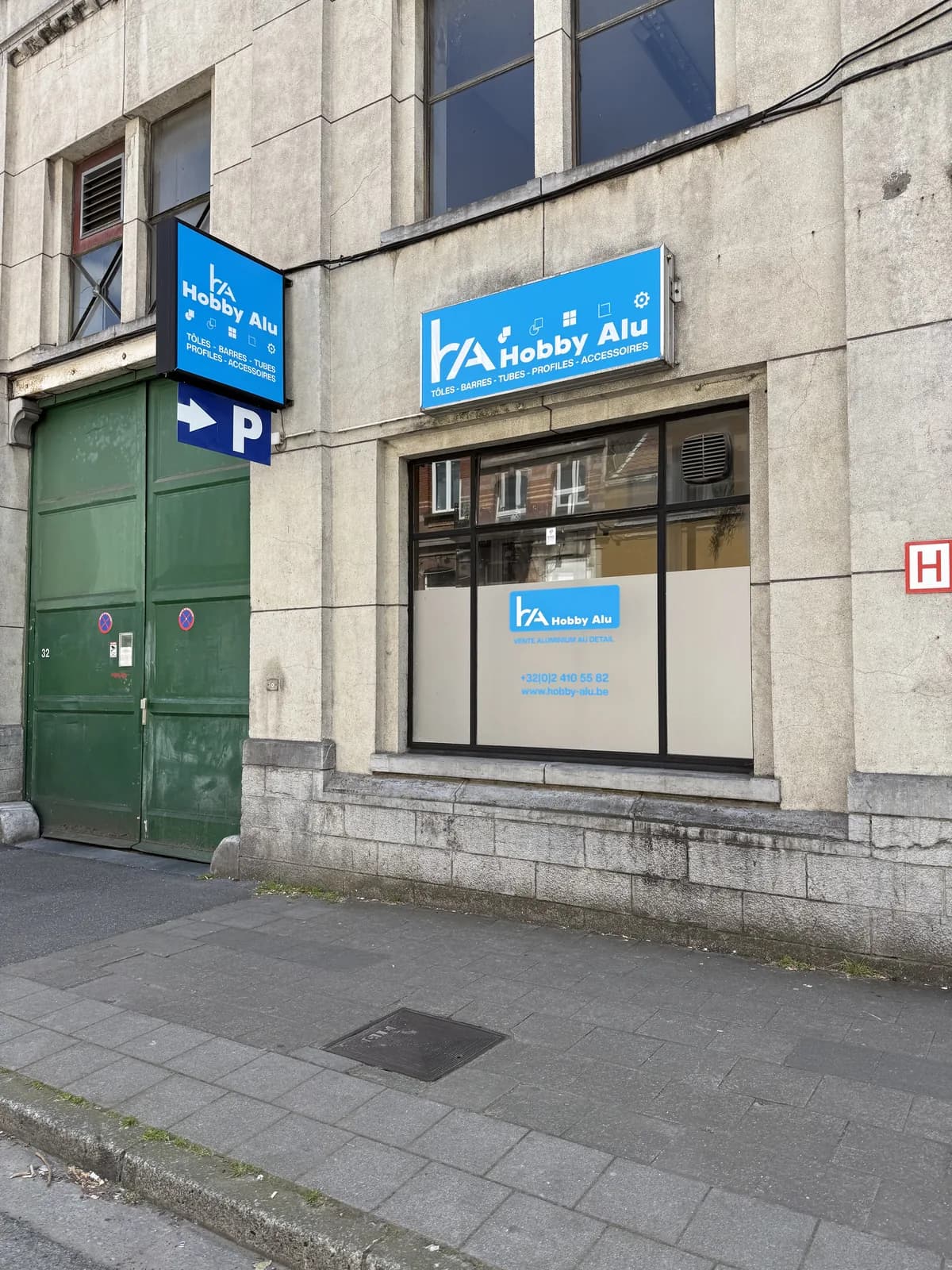 Enseigne caisson lumineux et panneaux bleus Hobby Alu, vente d'aluminium, posés en façade à Bruxelles
