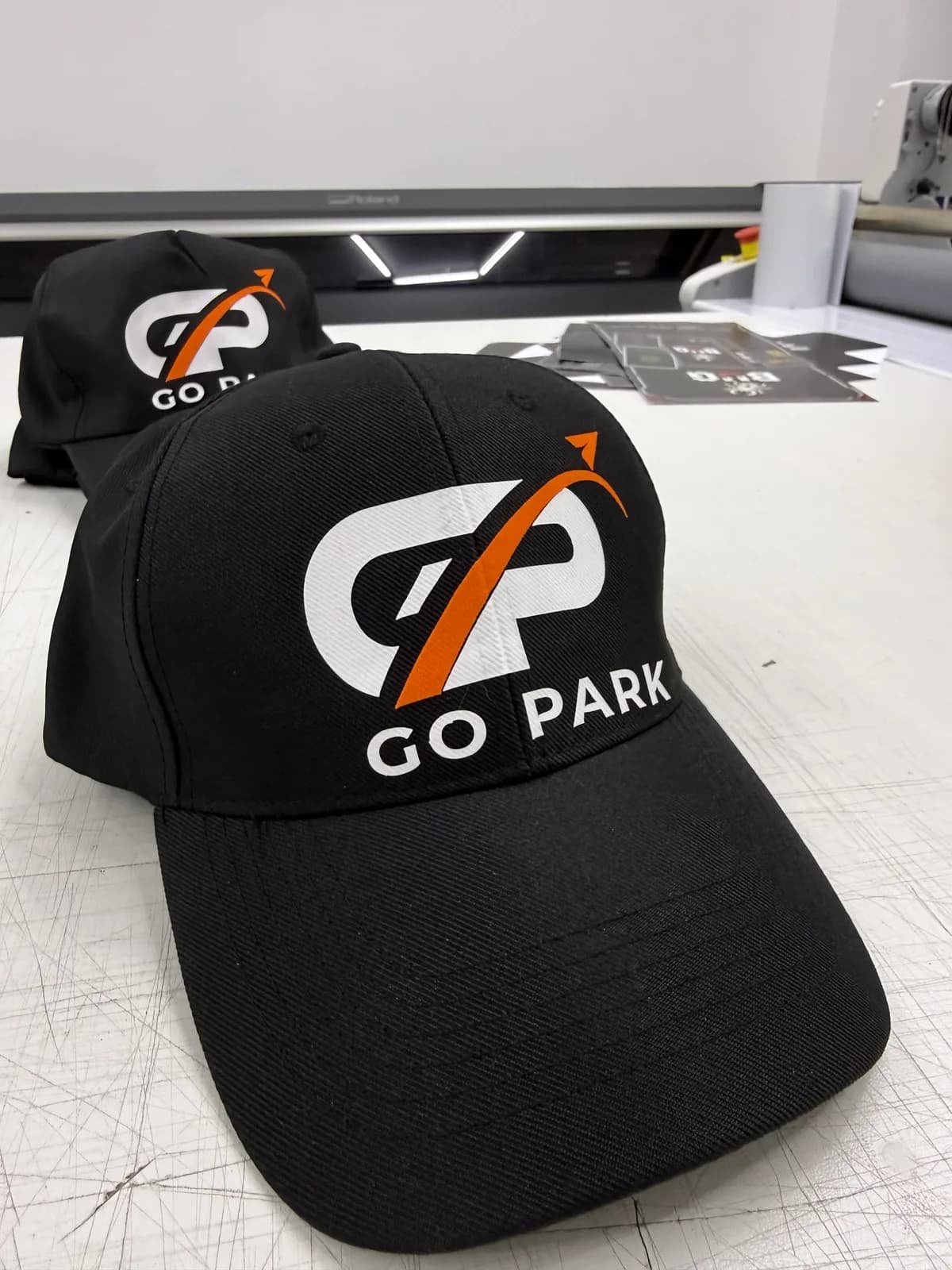 Casquettes noires brodées au logo GO PARK, personnalisation textile par AB2 Print